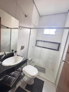 um banheiro com vaso sanitário, pia e chuveiro em Perto da área central em Sinop