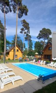Una piscina con tumbonas y una casa. en Ośrodek 9Amber, en Pobierowo