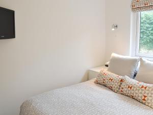 een slaapkamer met een bed en een tv aan de muur bij Happys in St Ives