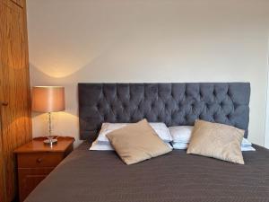 - un lit avec une tête de lit grise et 2 oreillers dans l'établissement Cottage 494 - Roundstone, à Roundstone