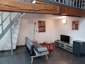 a living room with a couch and a tv at Beaugency-3 sur la route des châteaux in Beaugency