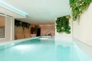 a swimming pool with plants on the walls at Hotiday Toscana Riparbella in Riparbella