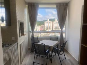 een eetkamer met een tafel en stoelen en een raam bij Sunshine 601 in Balneário Camboriú