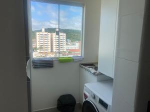 een keuken met een raam met uitzicht op de stad bij Sunshine 601 in Balneário Camboriú