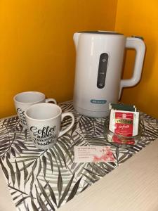 une table avec deux tasses et une cafetière dans l'établissement La Casa Dei Fiori, à San Maurizio Canavese