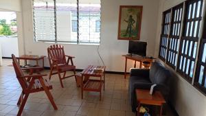 un salon avec un canapé, des chaises et une télévision dans l'établissement Bovenhuis Masusa, à Paramaribo