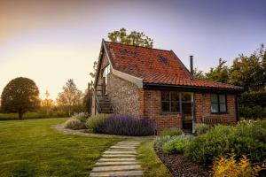 a brick house with a pathway leading to it at Granary Cottage in Wenhaston