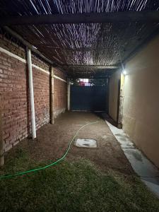 a room with a green hose attached to a brick wall at Casa con pileta y quincho in San Martín