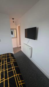 a room with a flat screen tv on a wall at Studio apartment in Fishponds in Bristol