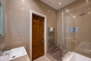 een badkamer met een douche, een bad en een wastafel bij Windsor Street Apartment in Edinburgh +49 foto's