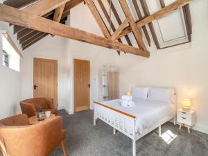 a bedroom with a white bed and a chair at Corley Rocks Barn - Uk45939 in Corley +10 photos