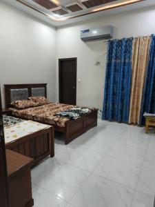 Una habitación con dos camas y una ventana. en Marhaba Guest House Multan, en Multán
