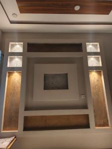 un techo artesonado con tres ventanas en una habitación en Marhaba Guest House Multan, en Multán