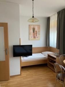 a small room with a bed and a flat screen tv at Penzion U Radnice in Kyjov