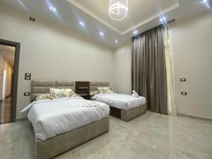 two beds in a room with lights on the ceiling at Luxury Apartments - Downtown Cairo in Cairo