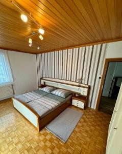 a bed in a room with a wooden ceiling at Rosental Privatunterkunft in Sankt Margareten im Rosental
