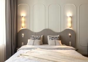 Un dormitorio con una cama grande con almohadas blancas. en Carillon Aparthotel - Keystone Collection, en Riga