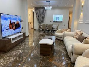 カイロにあるGrand Luxury Apartments - Downtown Cairoのテレビ、ソファ、テーブルのあるリビングルーム