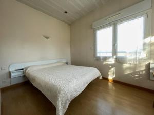 a bedroom with a bed and a window at Hôtel des Pyrénées in Laloubère