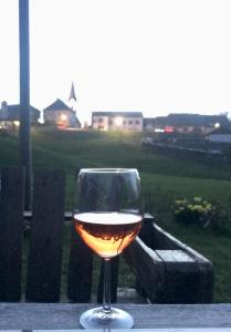 a glass of wine sitting on a table at Rosental Privatunterkunft in Sankt Margareten im Rosental
