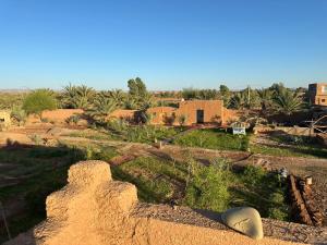 Una vista de un desierto con casas y palmeras. en Dar Tiniri - Guest House - Zagora, en Arhla Ou Drar