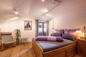 une chambre avec un lit, une chaise et une fenêtre dans l'établissement 4-Jahreszeiten, à Hopfgarten im Brixental