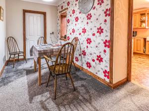 eine Küche mit Tisch und Stühlen in einem Zimmer in der Unterkunft Laxdale Cottage in Leverburgh