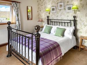 ein Schlafzimmer mit einem Bett und einem Fenster in der Unterkunft Laxdale Cottage in Leverburgh + 10 Fotos