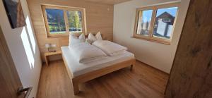 a bedroom with a bed with white sheets and pillows at Johler Appartements in Bezau