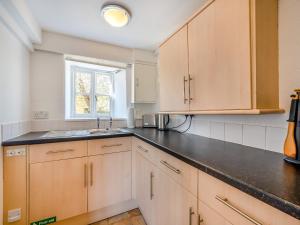 a kitchen with wooden cabinets and a sink at No18 - Uk48248 in Sturminster Newton