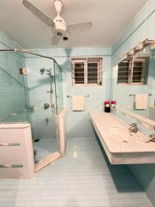 a bathroom with a glass shower and a sink at MELBERRY Guest House in Islamabad