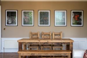 een tafel met drie stoelen en vier schilderijen aan de muur bij Windsor Street Apartment in Edinburgh