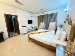 a bedroom with a large bed and a television at MELBERRY Guest House in Islamabad +24 photos