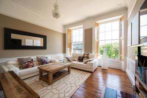 een woonkamer met een bank en een tafel bij Windsor Street Apartment in Edinburgh