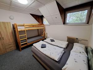 two beds in a room with a bunk bed at Chata JedlOvka in Jiřetín pod Jedlovou +19 photos