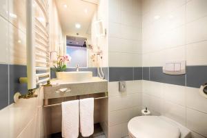 a bathroom with a toilet and a sink at Ferenc Hotel Budapest in Budapest