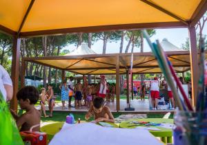 a group of children playing in the sand under a tent at Holiday Village in Fondi
