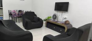 a living room with two chairs and a flat screen tv at BB Senawang Homestay in Seremban