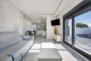 ein Wohnzimmer mit einem Bett und einem großen Fenster in der Unterkunft Villa Infinity 1 in Chiclana de la Frontera