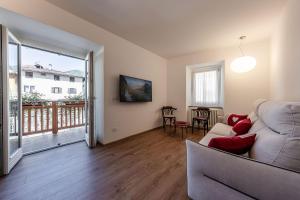 a living room with a couch and a balcony at Casa Slucca in Pellizzano