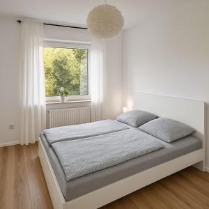 a white bedroom with a bed and a window at Köln Pulheim 48 in Pulheim +11 photos
