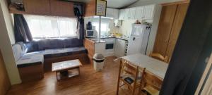 eine kleine Küche mit Couch und Kühlschrank in der Unterkunft Mobil-home climatisé 4 pers 2 chambres in Messanges
