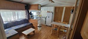 eine kleine Küche mit einem Sofa und einem Tisch in einem Zimmer in der Unterkunft Mobil-home climatisé 4 pers 2 chambres in Messanges + 3 Fotos
