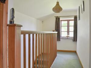 a hallway with a wooden railing and a window at Holly Bank in Crich +9 photos