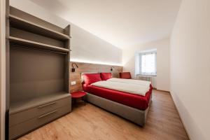 a bedroom with a bed with red pillows at Casa Slucca in Pellizzano