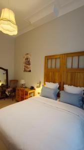 een slaapkamer met een groot wit bed met blauwe kussens bij Marilou and Dalibor's room in Brussel