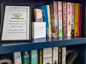 a shelf full of books on a shelf at The Colleys in Lechlade
