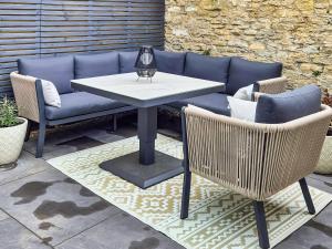 a table and two chairs and a couch on a patio at The Colleys in Lechlade