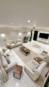 a large living room with couches and a flat screen tv at فيلا آنسي Villa Annecy in AlUla