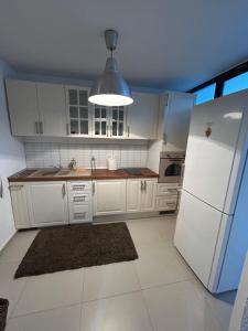 a kitchen with white cabinets and a white refrigerator at Villa Apartments in Craiova